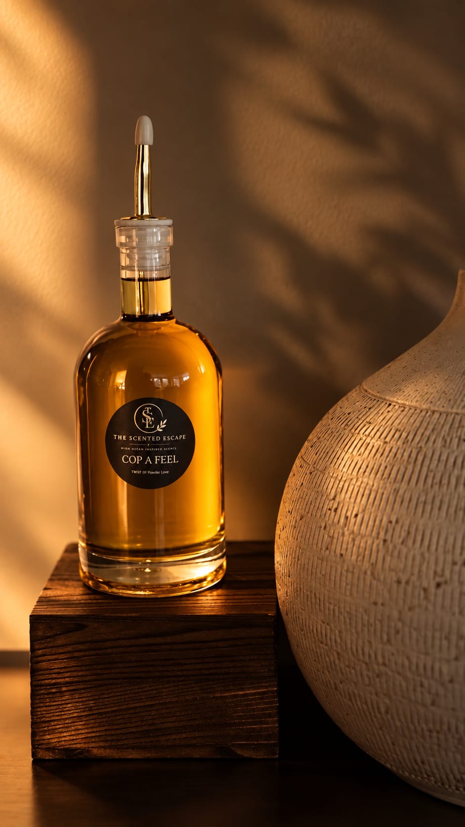 Cop a Feel perfume oil in a glass decanter on a wooden block